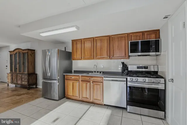 a kitchen with stainless steel appliances granite countertop a stove top oven and refrigerator