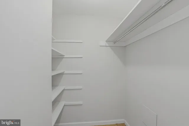 a view of walk in closet with empty racks