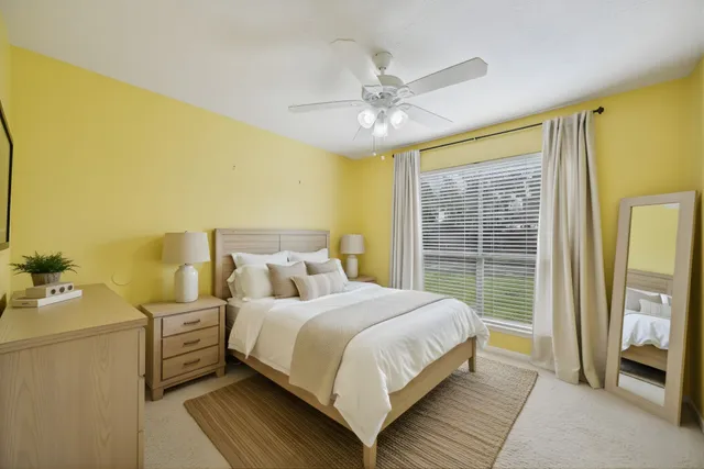 a bedroom with a bed and large windows