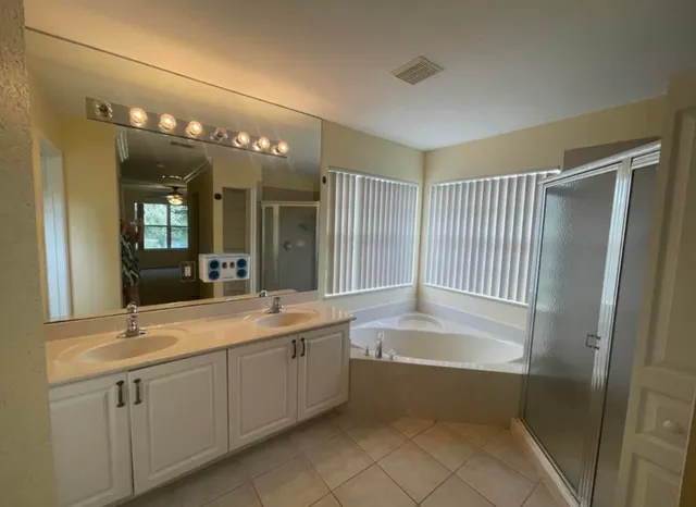 a bathroom with a tub sink and mirror