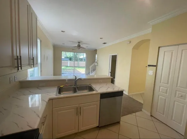 a kitchen with stainless steel appliances granite countertop a sink and a refrigerator
