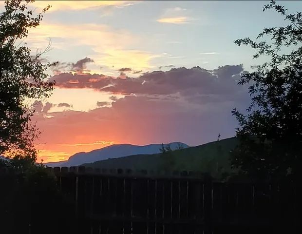 a view of mountain with sunset in background