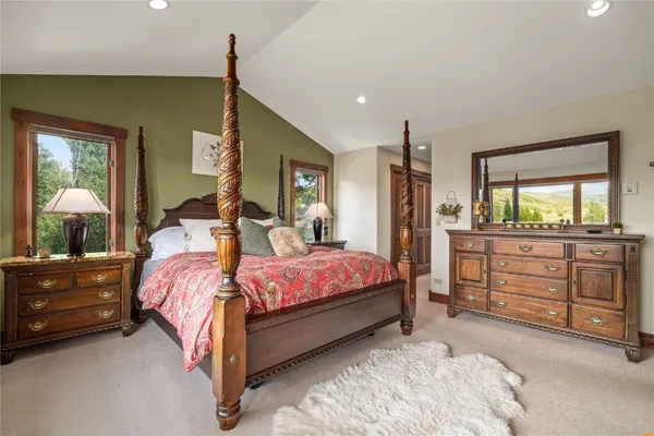 a bedroom with a bed a flat screen tv and a large window