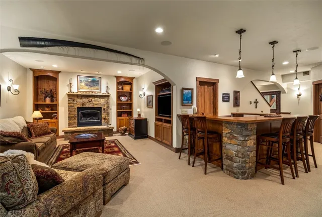a living room with furniture a table and kitchen view