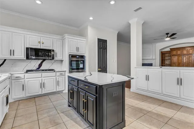 a kitchen with granite countertop a sink and a stove top oven