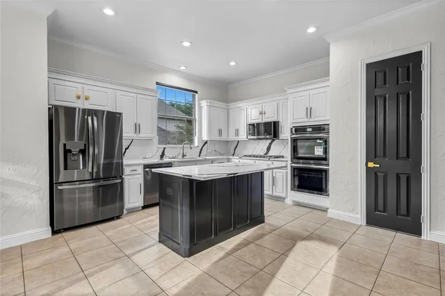 a kitchen with stainless steel appliances granite countertop a refrigerator and a sink