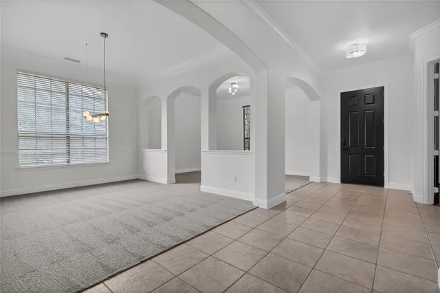 an empty room with windows and ceiling fan