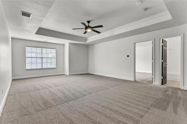 an empty room with windows and ceiling fan