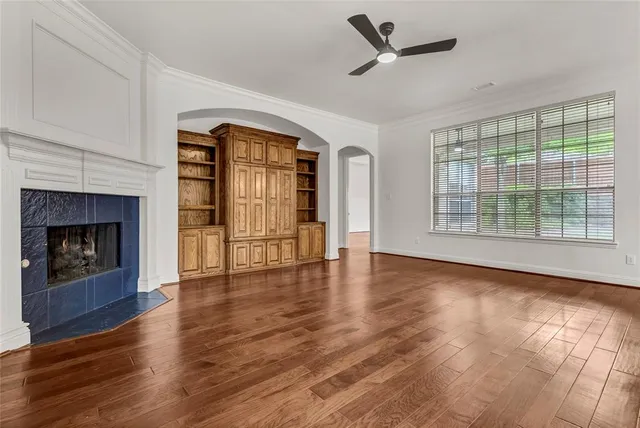 a view of an empty room with window and wooden floor
