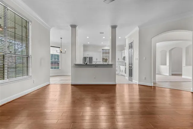 a view of a big room with wooden floor and windows