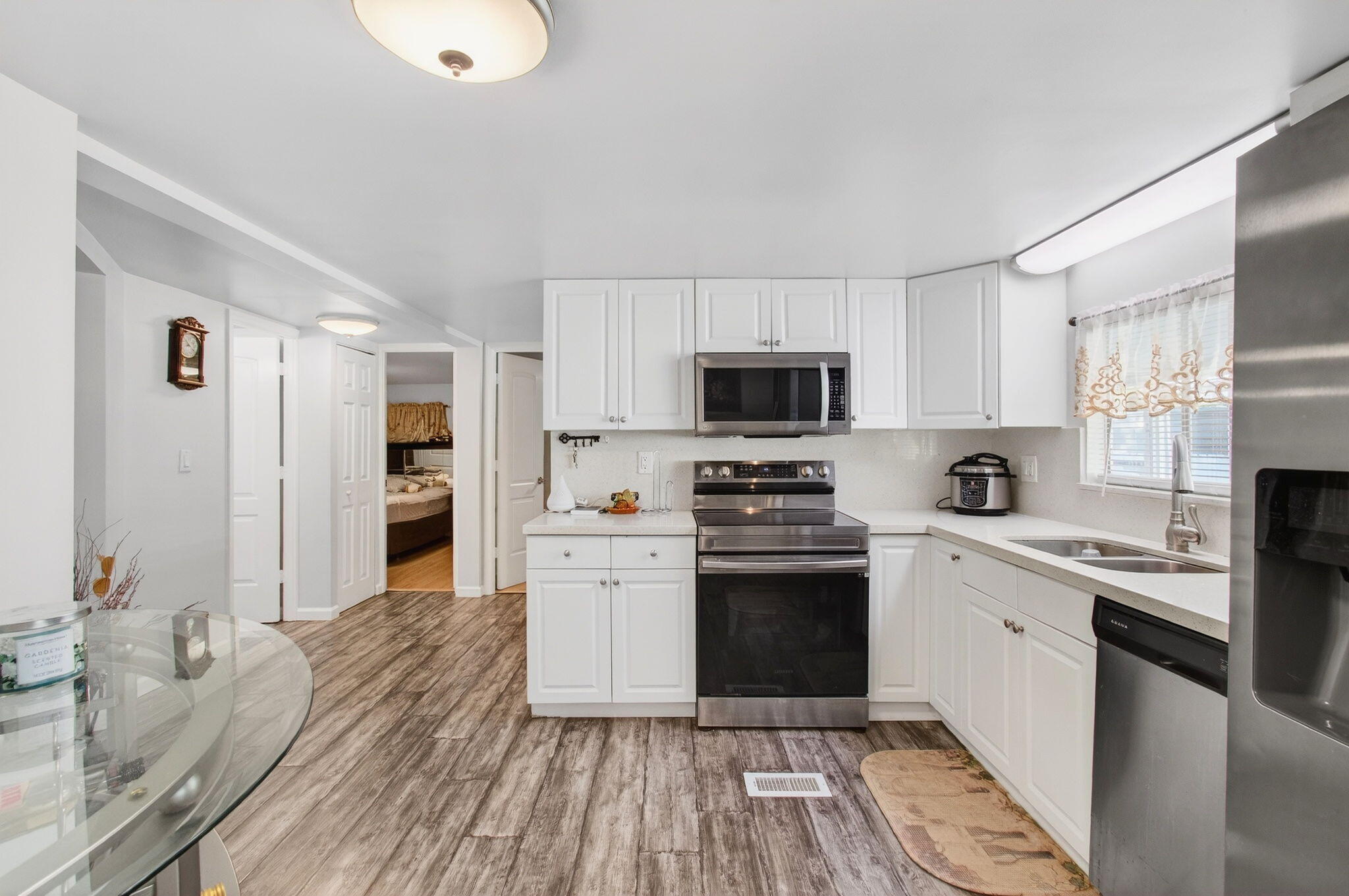 22849 Tradewind Road Boca Raton, FL 33428 - Photo 14 of 60 a kitchen with a sink wooden floor and stainless steel appliances