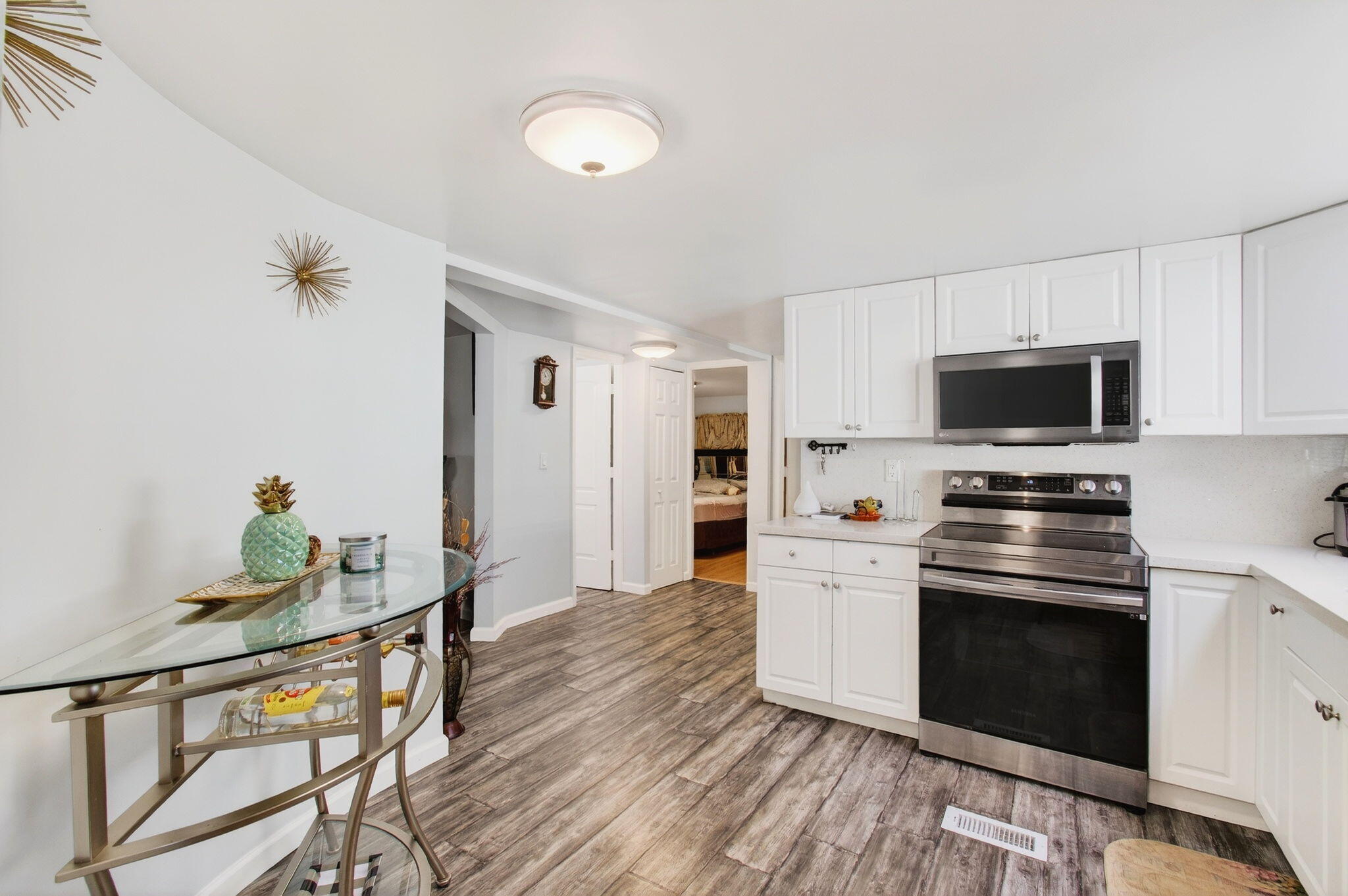 22849 Tradewind Road Boca Raton, FL 33428 - Photo 15 of 60 a kitchen with granite countertop a stove and a wooden floor