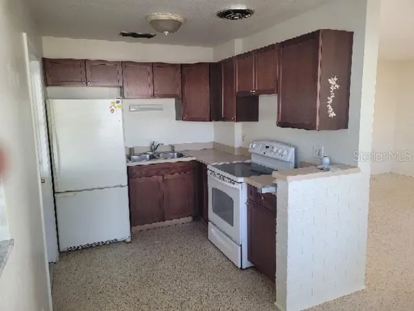a kitchen with a stove sink and refrigerator
