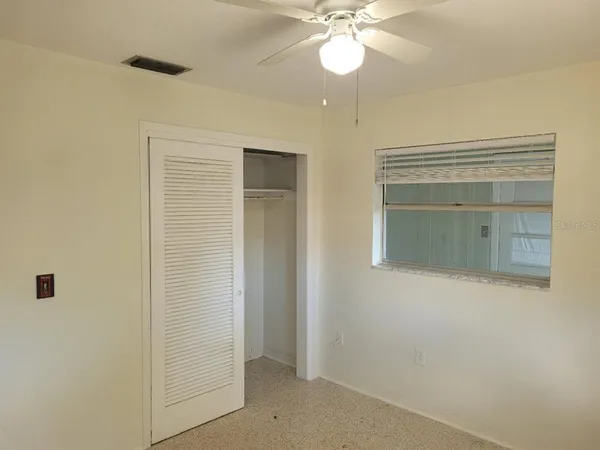 an empty room with a mirror and a fan