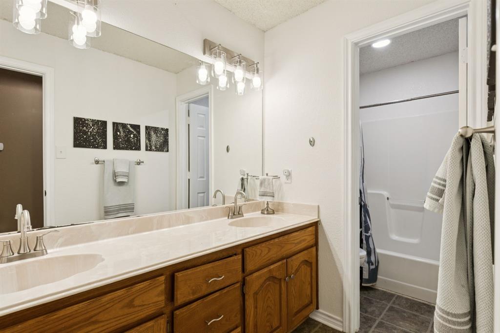 13768 Stirrup Court Forney, TX 75126 - Photo 20 of 32 a bathroom with a double vanity sink a mirror and shower
