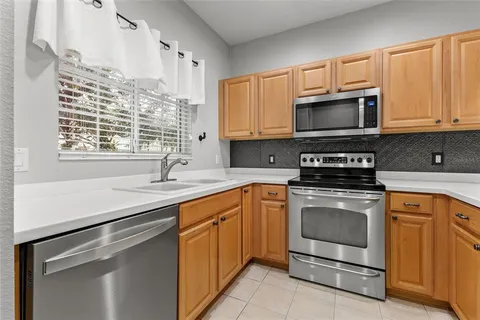 a kitchen with granite countertop a sink stainless steel appliances and cabinets