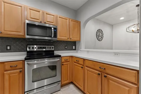 a kitchen with white cabinets and black appliances