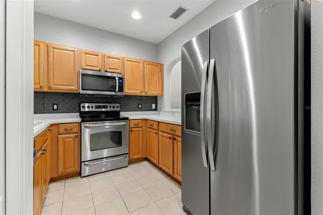 a kitchen with stainless steel appliances granite countertop a refrigerator stove and sink