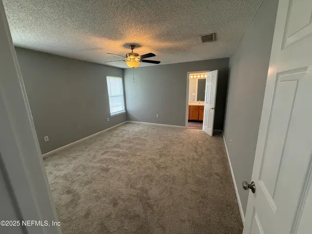 a view of a room with a ceiling fan and window