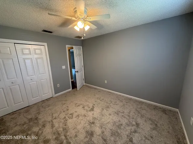 an empty room with chandelier fan