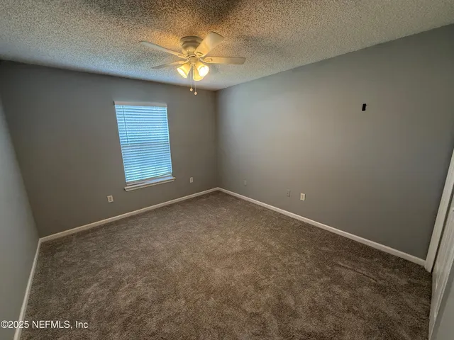 an empty room with a chandelier fan