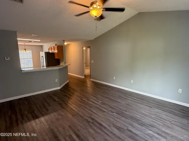 a view of a livingroom with a ceiling fan and hardwood floor