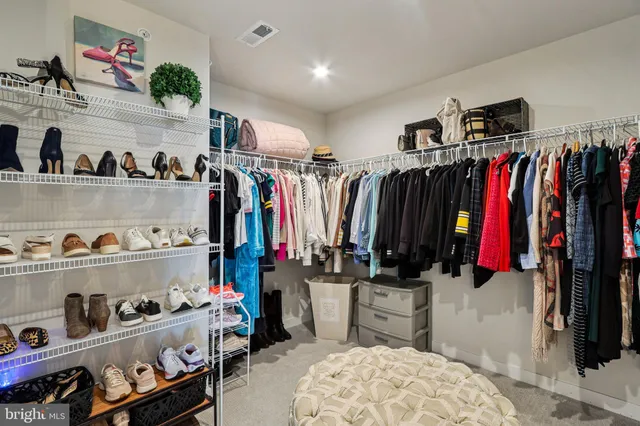 a view of a hallway with bathroom and wooden floor