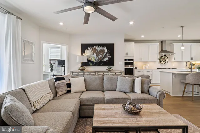 a living room with furniture kitchen view and a large window
