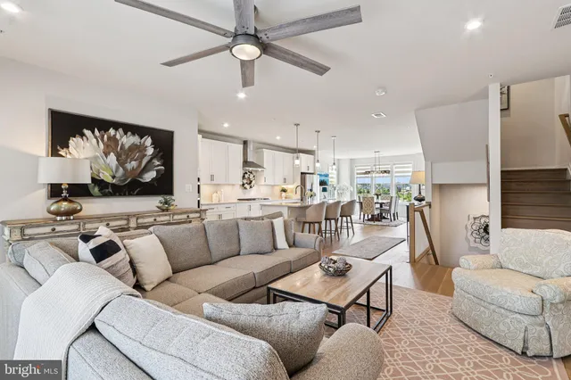 a living room with furniture kitchen view and a flat screen tv