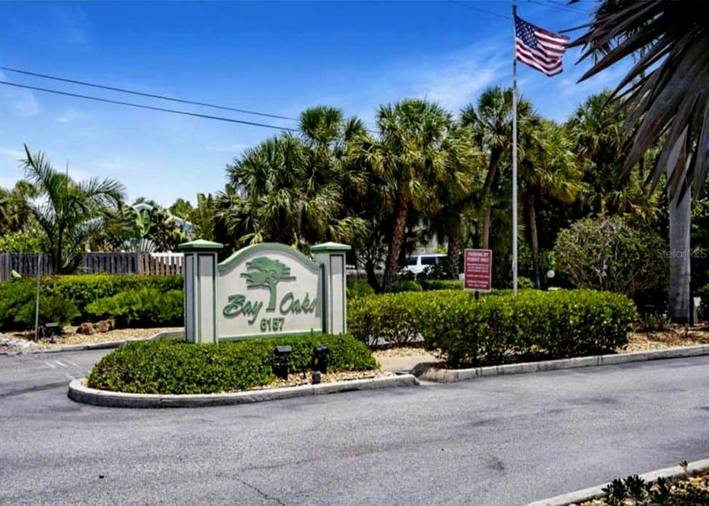 6157 Midnight Pass Road, Unit E63 Sarasota, FL 34242 - Photo 31 of 61 a front view of a house with a garden