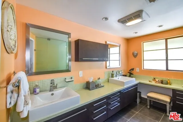 a bathroom with a granite countertop sink and a large mirror