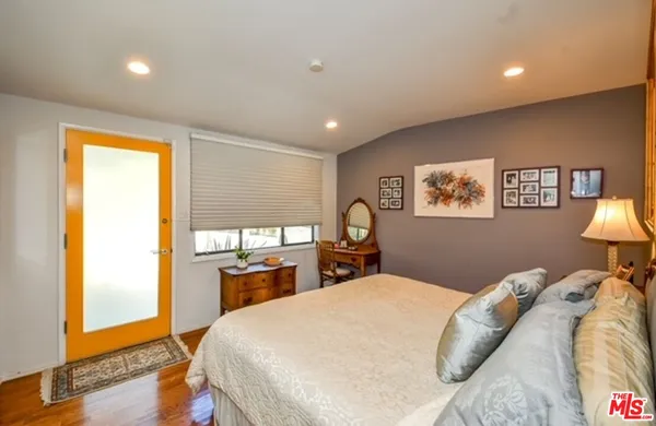 a bed sitting in a bedroom next to a window