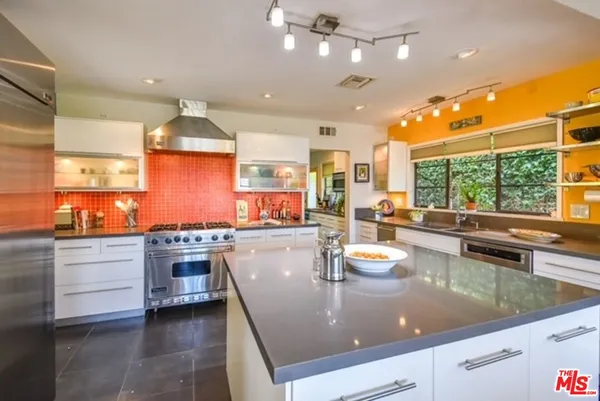 a kitchen with stainless steel appliances granite countertop a sink counter space cabinets and a stove