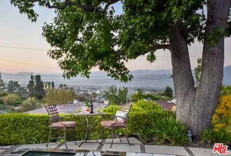 a view of a city with flower plants and wooden fence