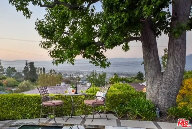 a view of a city with flower plants and wooden fence