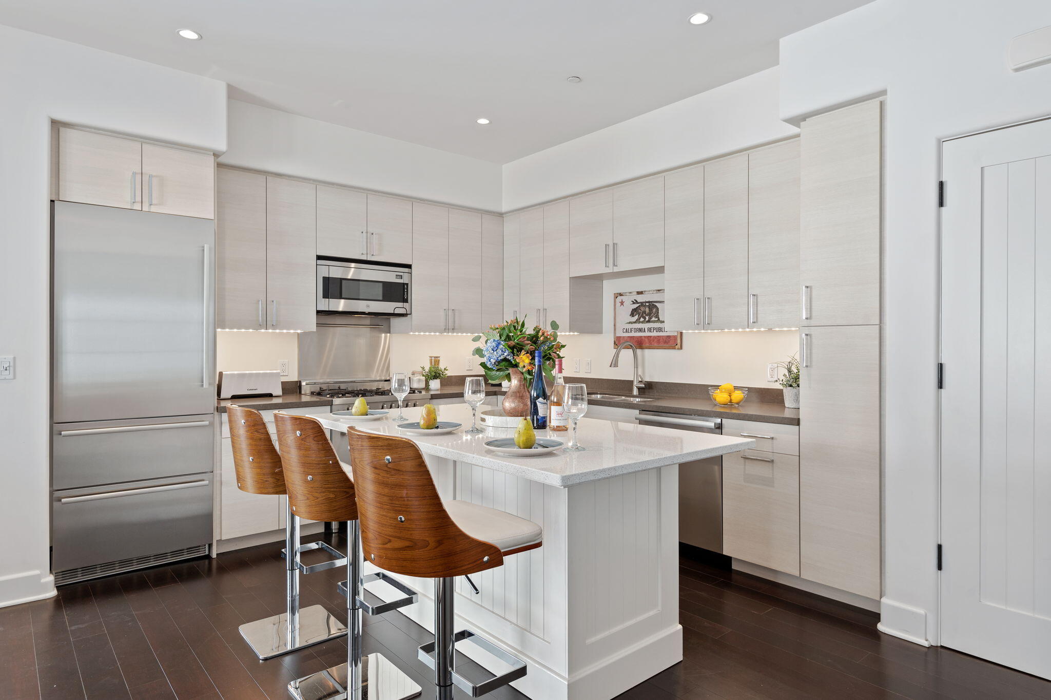 18 West Victoria Street, Unit 303 Santa Barbara, CA 93101 - Photo 6 of 42 a kitchen with kitchen island white cabinets and stainless steel appliances