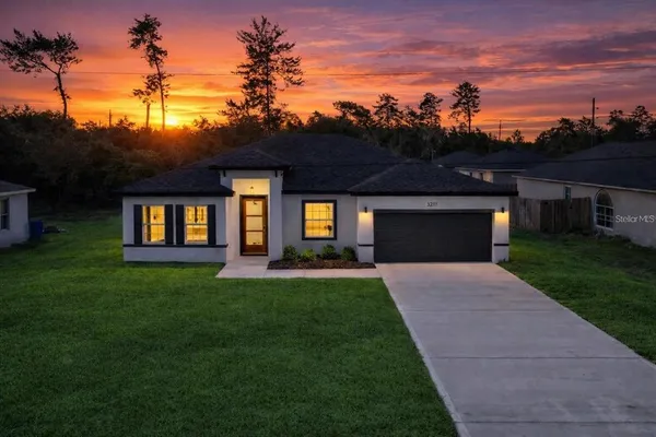 a front view of a house with a yard and trees