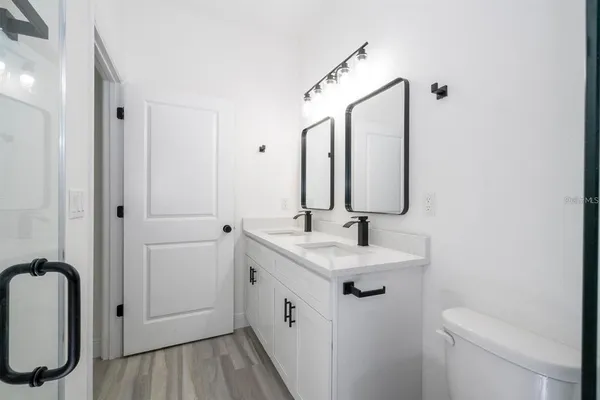a bathroom with a double vanity sink mirror and toilet