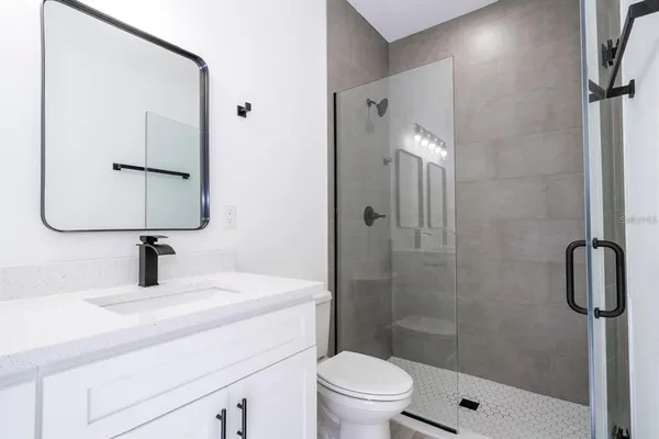 a bathroom with a sink toilet a mirror and shower