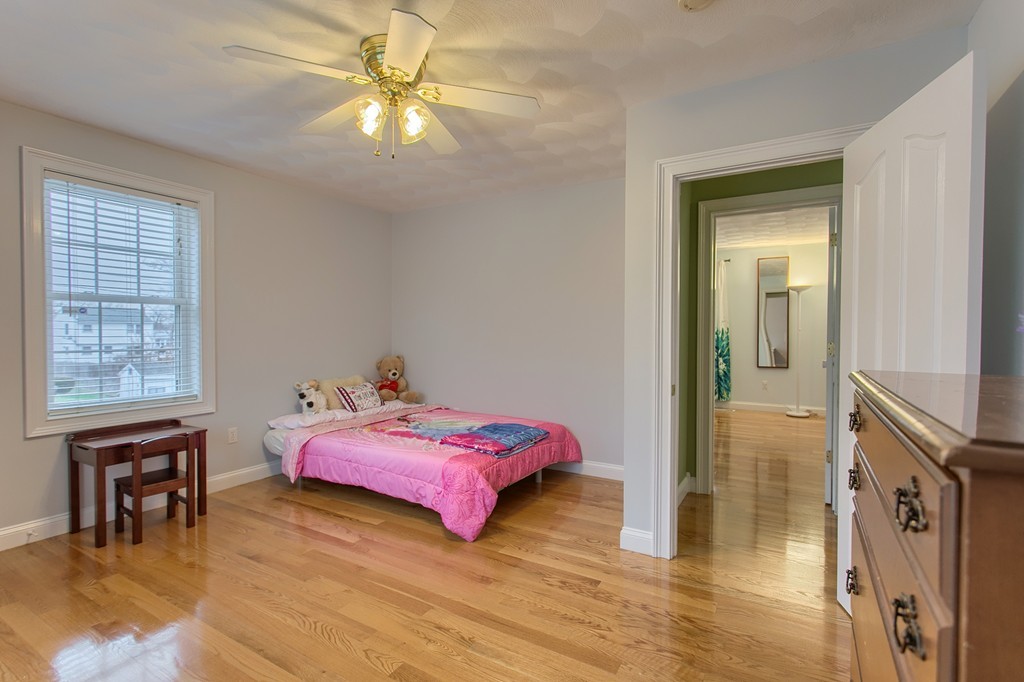 918 Boston Road Billerica, MA 01821 - Photo 13 of 16 a bedroom with a bed and a chandelier