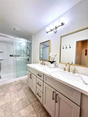a spacious bathroom with a granite countertop sink a mirror and a shower