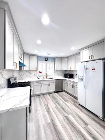 a kitchen with white cabinets and white appliances