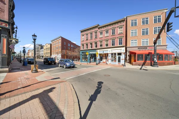 a city street lined with buildings and cars parked on the street