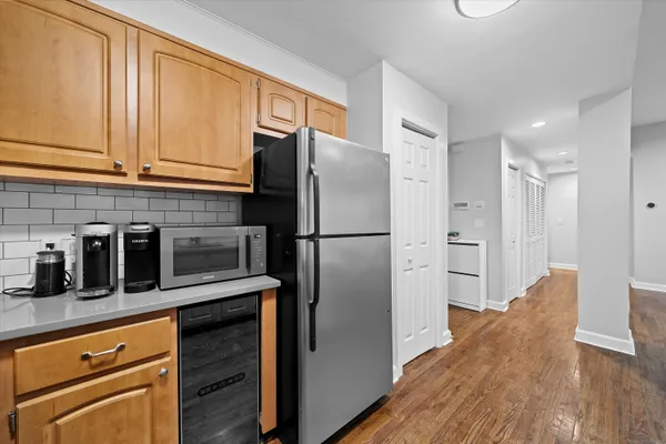 a kitchen with stainless steel appliances granite countertop a refrigerator a stove and a sink with wooden floor