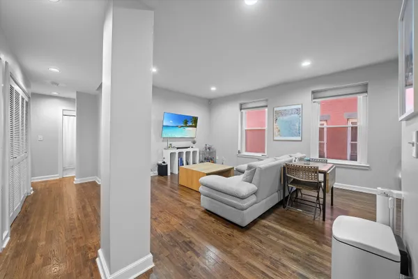 a living room with furniture and a wooden floor