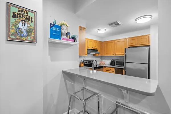 a kitchen with stainless steel appliances a refrigerator and microwave