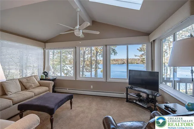 a kitchen with granite countertop a stove a sink and white cabinets with wooden floor next to windows