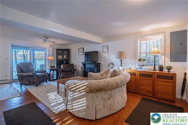 a living room with furniture a piano and a flat screen tv