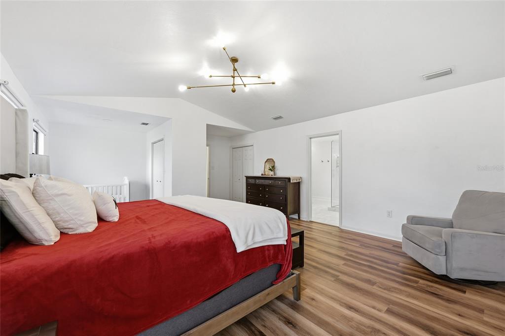 6612 Northwest 44th Place Gainesville, FL 32606 - Photo 18 of 34 a bedroom with bed and wooden floor