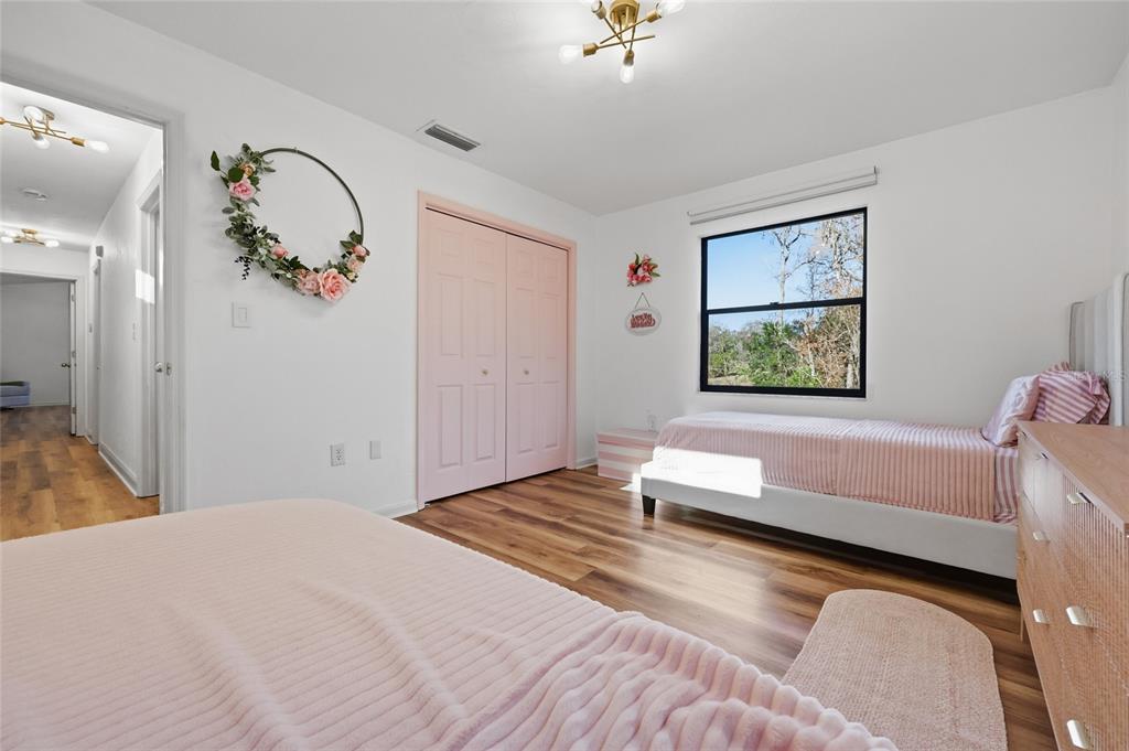 6612 Northwest 44th Place Gainesville, FL 32606 - Photo 25 of 34 a bedroom with a bed and a chandelier